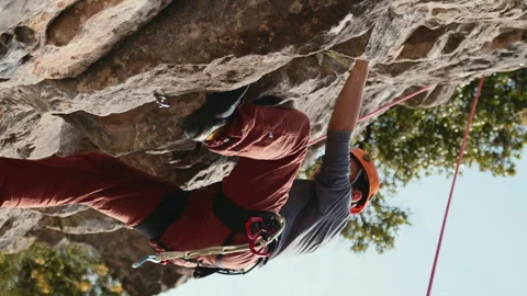 Gravity-Defying Rock Climber Reaching for the Next Hold on a Challenging Stock Footage 273799518