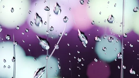 Gravity pulling cluster of water droplets, merging into vertical streaks on Stock Footage 341889678
