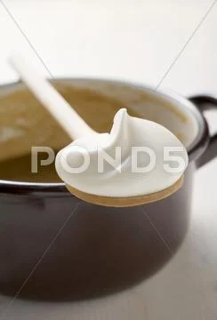 Gravy in pan, wooden spoonful of crme fra”che resting on pan Stock Photos