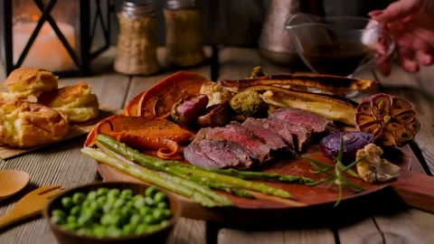 Gravy Poured on Appetizing Juicy Beef Sunday Roast with Vegetables Stock Footage 326321389
