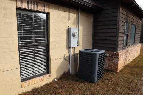 Gray Air Conditioner Condensor unit next to home Stock Photos