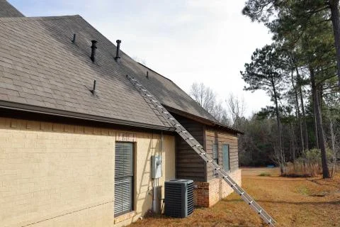 Gray Air Conditioner Condensor unit and ladder next to home Stock Photos