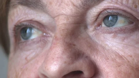 The gray and beautiful eyes of an old woman whose face is wrinkled. Mom and Stock Footage 229866722