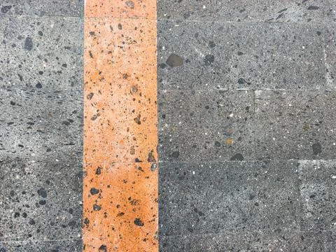 A gray and black tile wall with a black and gray stone pattern with orange line Stock Photos