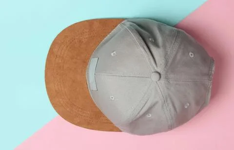 Gray and brown baseball cap on pastel pink and blue background Stock Photos