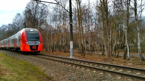A gray-and-red electric train passing by Stock Footage 145028008