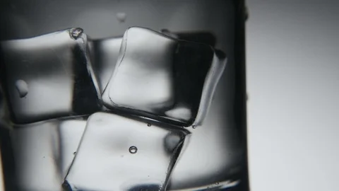 Gray and white ice cubes are shaken in a crystaline glass in the grey background Stock-Footage 87648039
