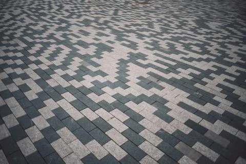 Gray and white patterned paving tiles on the ground of street, perspective vi Stock Photos
