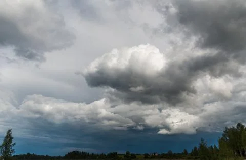 Gray and white storm clouds on a dark blue sky Stock Photos