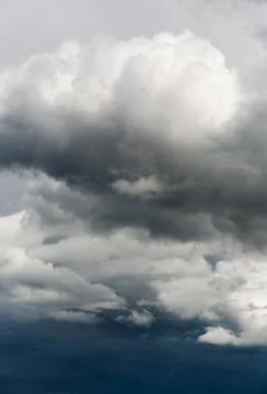 Gray and white storm clouds on a dark blue sky Stock Photos