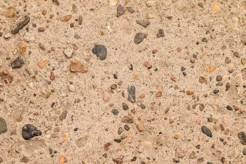Gray background. Concrete and colored pebbles Stock Photos