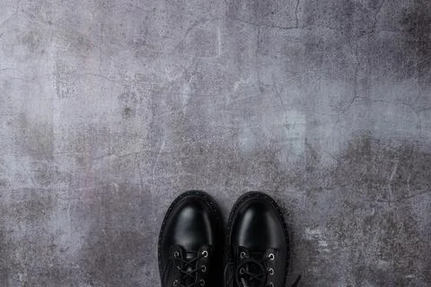 Gray background with pair black boots Stock Photos