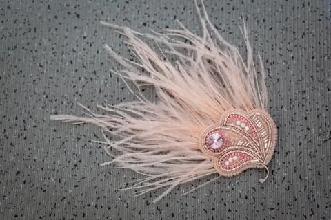 Gray background with pink handmade feather brooch Stock Photos
