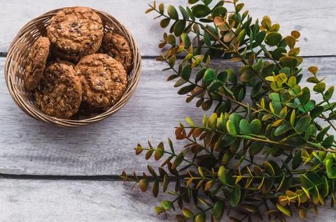 On a gray background, a plate with cookies. Eucalyptus nearby. Foto stock