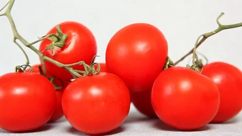 Gray background with red tomatoes, hands making free copy space Stock Footage 75907761