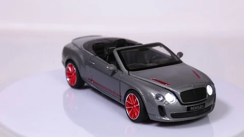Gray Bentley Continental scale model sports car is rotating isolated on white 스톡 동영상 101728202