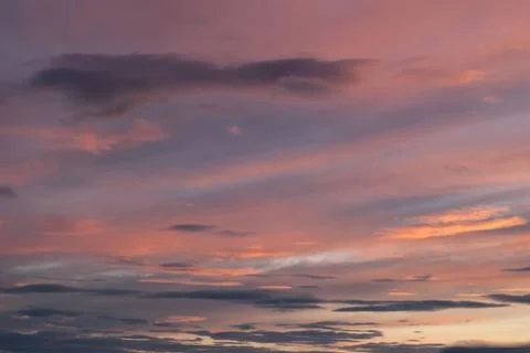 Gray, blue and orange clouds at sunset Stock Photos