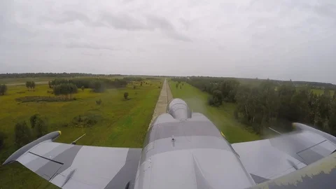 A gray blue plane fly very quickly and low above the ground. Top view from tail. Stock Footage 118677246