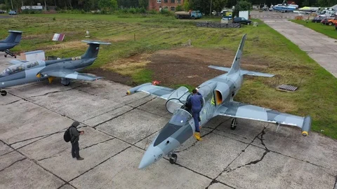 Gray blue training fighter plane stand at the old airfield. Top view from drone. Stock Footage 118672596