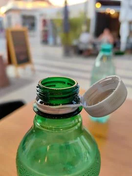 Gray bottle cap attached to green bottle, environmental friendly solution Fotos Stock