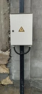 A gray box with a yellow triangle on it, which means electricity.  Foto stock