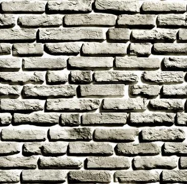 Gray brick wall forming a textured background with light and shadow Stock Photos