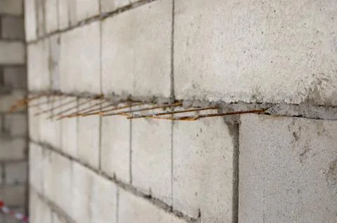 Gray brick wall with iron bars reinforcement during construction Stock-Fotos