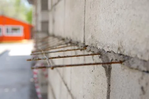 Gray brick wall with iron bars reinforcement during construction Foto stock