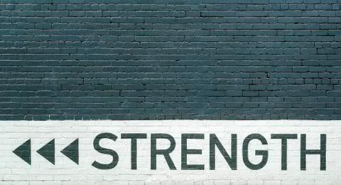 Gray brick wall vith strength motto Stock Photos