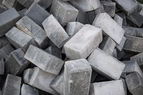 Gray bricks are stacked together, ready to be used in a construction project, Stockfoto's