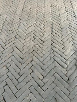 Gray bricks laid in herringbone pattern Stock Photos