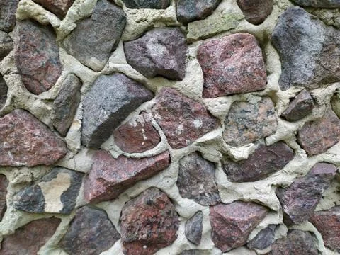 Gray, brown, black stone wall background, granite mosaic stonewall rubble fac Stock Photos
