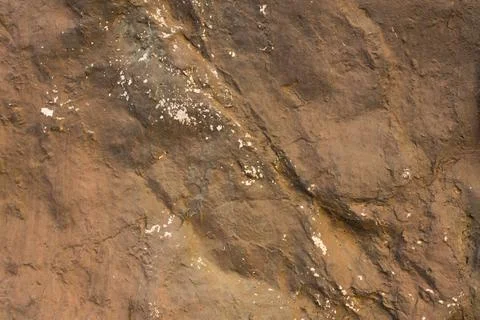 Gray brown stone with deep relief, shadows and white spots. natural surface t Stock Photos