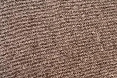 A gray-brown textured surface of a synthetic carpet with a close-up with ro.. Stock Photos