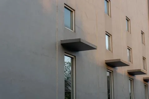 Gray building facade with rectangular windows evenly arranged Stock Photos