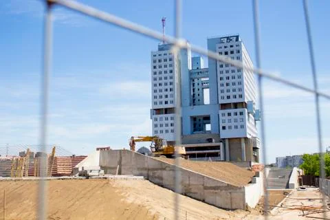 Gray building under construction behind the fence Stock Photos