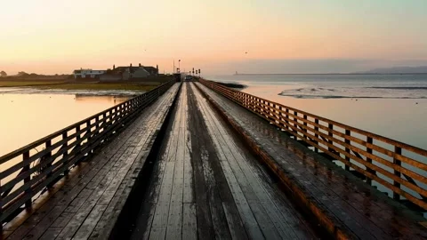 A gray car drives down an empty country road at a golden summer sunset Stock Footage 275645095