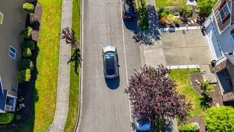 Gray car driving through suburban neighborhood, arriving at home Stock Footage 278748335