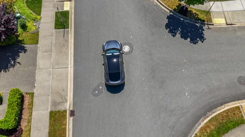 Gray car driving through suburban neighborhood, arriving at home Stock Footage 278823391