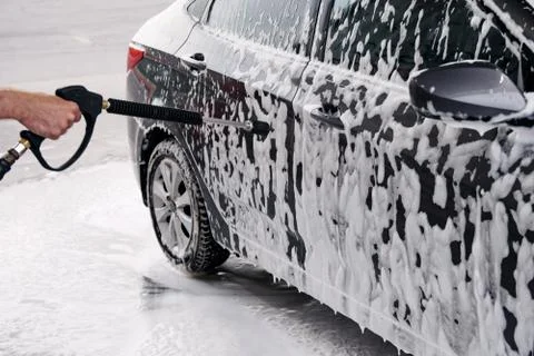 Gray car washed at the sink through a foam gun Stock Photos