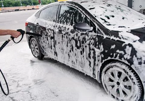 Gray car washed at the sink through a foam gun Stock Photos