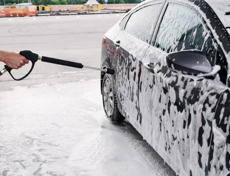 Gray car washed at the sink through a foam gun Stock Photos