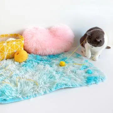 Gray cat tangled yellow threads for knitting. Stock Photos