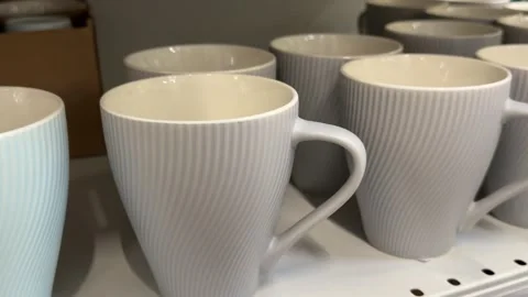 Gray ceramic mugs with soft blue cups arranged on retail shelves in a modern Stock Footage 345173101