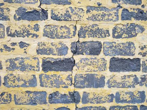 Gray cinder block wall with yellow peeling paint Stock Photos