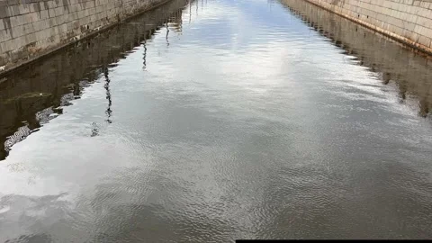 Gray city river and cloudy sky. Red houses along the road 動画素材 203783185