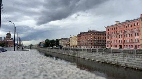 Gray city river and cloudy sky. Red houses along the road 動画素材 203783197