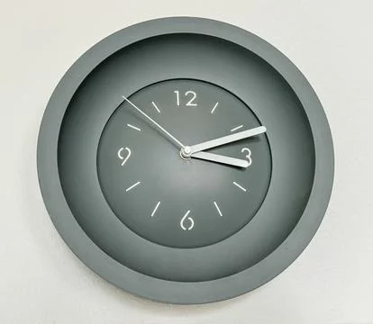 Gray clock on a white wall Stock Photos