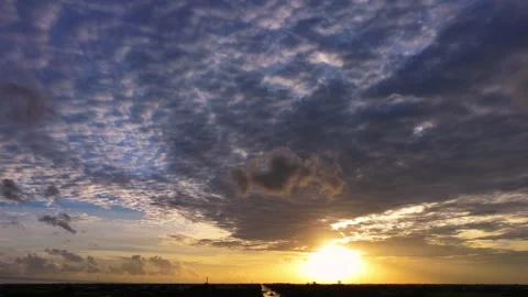 Gray cloud hovering in the middle of a golden sunset sky Stock Footage 344838670