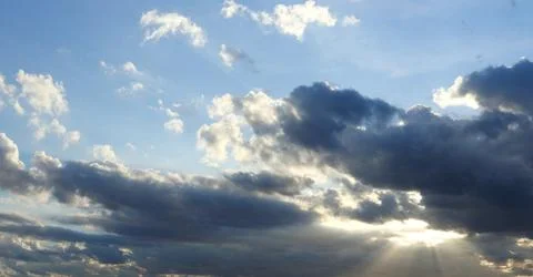 Gray clouds and blue sky with sunlight through. Stock Photos
